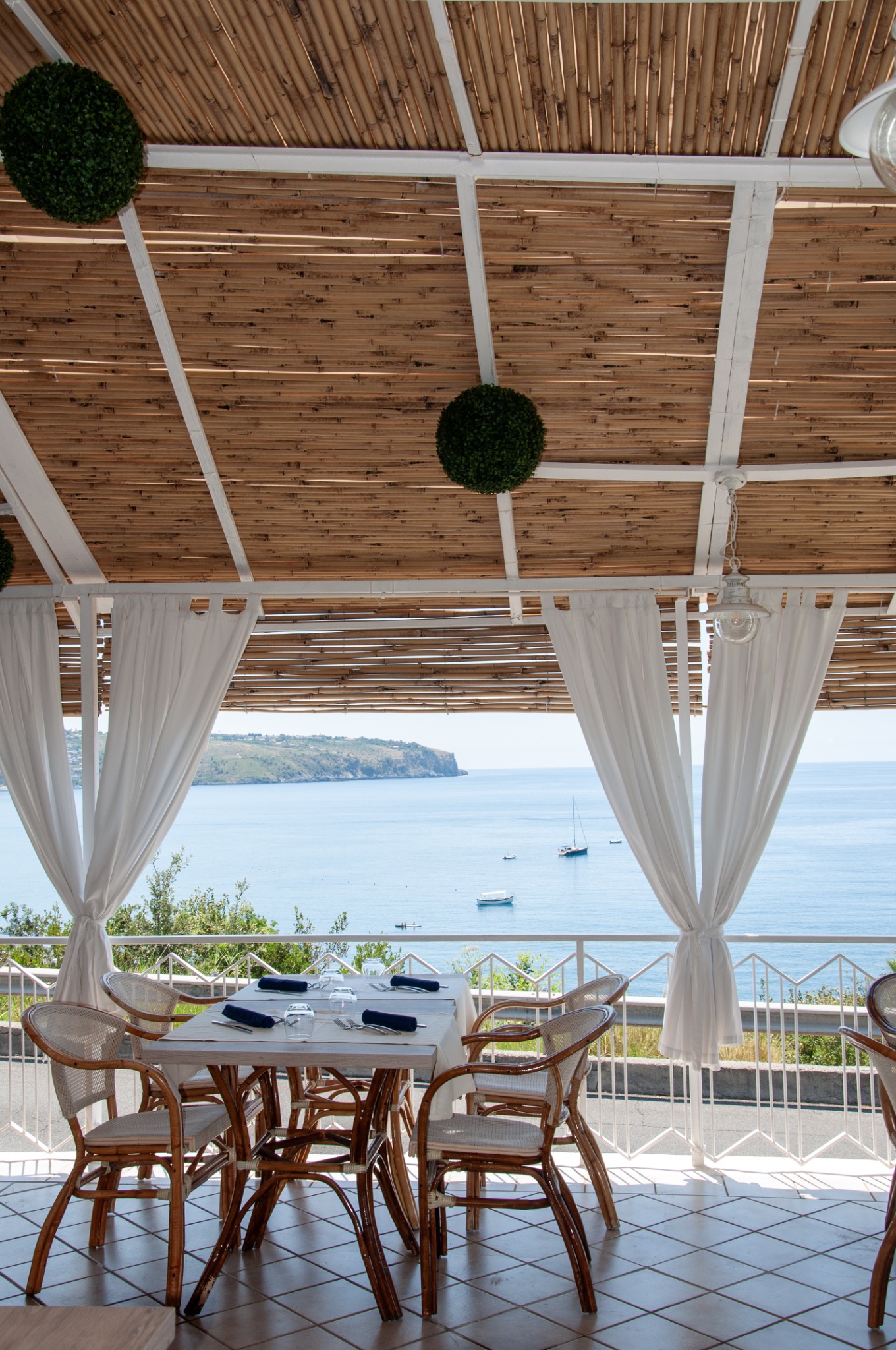 Tavolo apparecchiato in terrazza con vista mare
